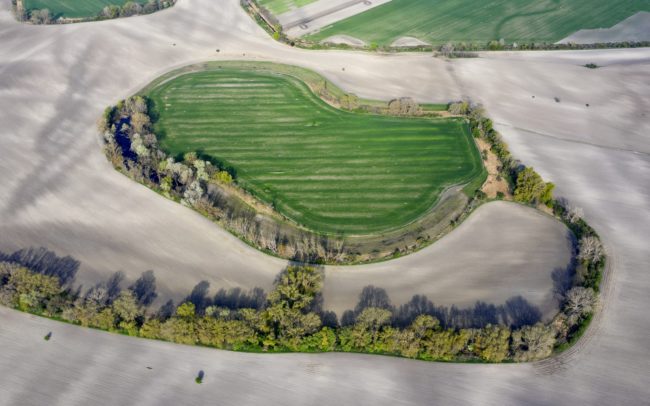 Falum, Nyékvárkony határában, Kenderes környékén van egy tavacska a fák között megbújva. A fotón is látható, a bal felén kéklik. Emlékeim szerint gyermekkori kalandozásaim legtávolabbi pontja, az akkori világvégém volt, eddig merészkedtem. Csak fentről nézve tűnik fel, hogy valójában egy lefűződött holtág legmélyebb pontja, szinte mindig vízzel telve. De a folyóhuroknak a további részei is alacsonyan vannak, a laposban a legtöbb termény nem nő meg. A régi térképek tanúsága szerint már pár évszázada másképpen gazdálkodnak rajta, mint a környékén, megőrizve ezzel a holtág holtág eredeti alakját.