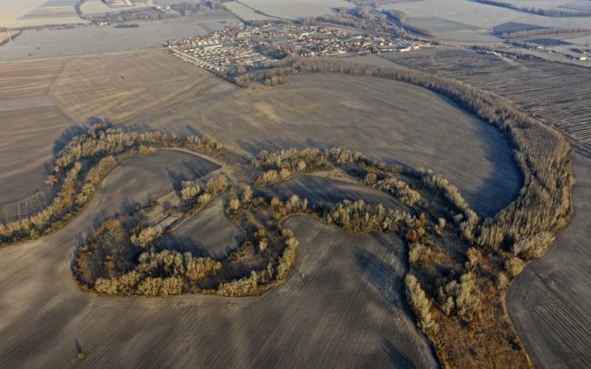 Driving on the road connecting settlements of Mad and Dolný Bar, or on road 63 between Dolný Bar and Dolný Štál, you might not notice anything special in the landscape. However, viewed from above, as the world expands, the flat landscape becomes very diverse. You will immediately see that one shape completely dominates and defines the surroundings. The former river in this part was called Hann (Han). Its forested and bushy line, rich in reeds, meanders thickly - this is one of the most striking single-use rivers in the Csallóköz. At the edge of Dolný Štál, the waterways of the past and the paved roads of the present cross each other, and even the superficial observer can get an insight into the secrets of the former. Great Rye Island, Slovakia.
