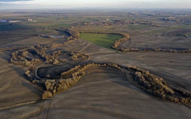 Driving on the road connecting settlements of Mad and Dolný Bar, or on road 63 between Dolný Bar and Dolný Štál, you might not notice anything special in the landscape. However, viewed from above, as the world expands, the flat landscape becomes very diverse. You will immediately see that one shape completely dominates and defines the surroundings. The former river in this part was called Hann (Han). Its forested and bushy line, rich in reeds, meanders thickly - this is one of the most striking single-use rivers in the Csallóköz. At the edge of Dolný Štál, the waterways of the past and the paved roads of the present cross each other, and even the superficial observer can get an insight into the secrets of the former. Great Rye Island, Slovakia.